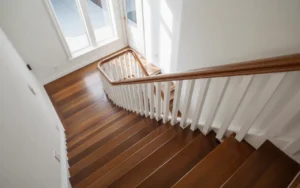 Modern wooden staircase with white railing shown after a full upgrade, illustrating how to remodeling outdating stairs in a bright updated home interior.