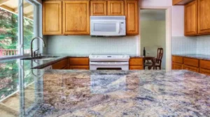 Countertop Installation Cost: Polished granite countertop with blue and beige veining installed in a kitchen with oak cabinets and tile backsplash, showing countertop installation cost quality