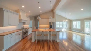 Raised Ranch Open Concept Kitchen featuring white shaker cabinets, butcher block island with seating, hardwood floors, and pendant lighting open to living area