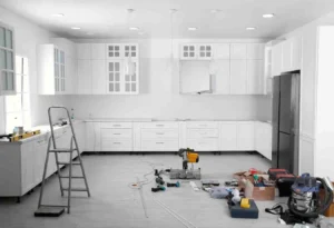 10×10 Kitchen Remodel Cost with white custom cabinets, modern lighting, luxury vinyl flooring, and kitchen renovation tools during remodeling project.