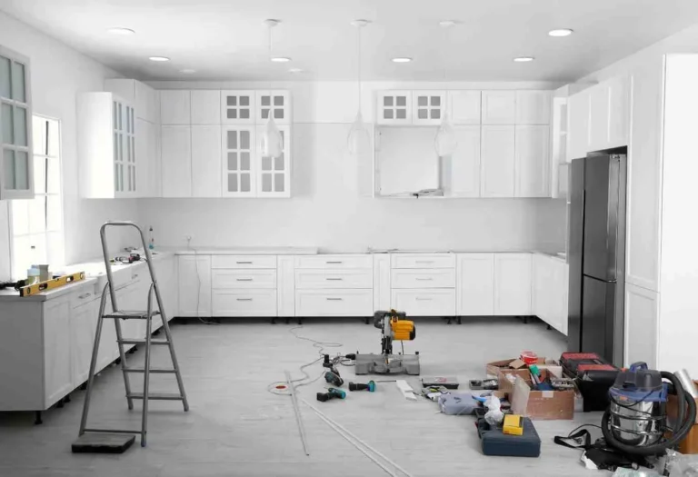 10×10 Kitchen Remodel Cost with white custom cabinets, modern lighting, luxury vinyl flooring, and kitchen renovation tools during remodeling project.