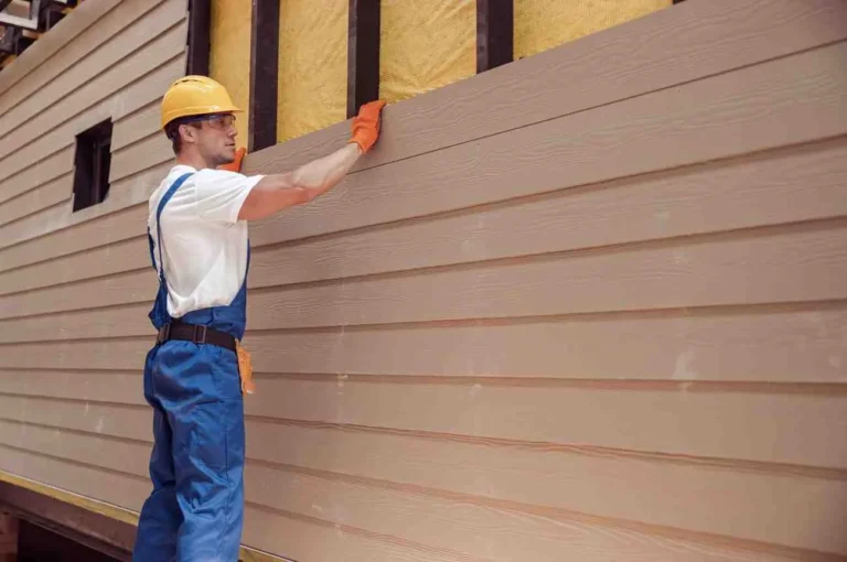 Benefits to Replacing Your Home’s Siding. Contractor installing new vinyl siding on a house to improve curb appeal, energy efficiency, and exterior protection