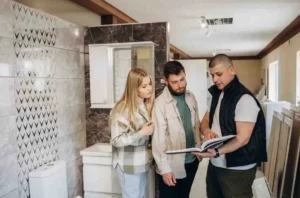 Homeowners meeting with a contractor to discuss How to Plan a Bathroom Remodel inside a modern bathroom showroom