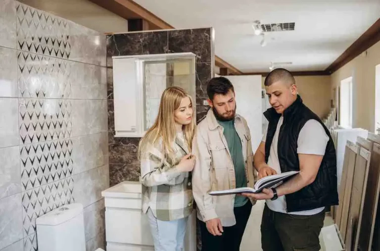 Homeowners meeting with a contractor to discuss How to Plan a Bathroom Remodel inside a modern bathroom showroom
