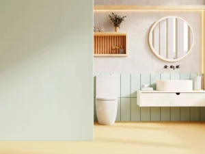 How to Pick Bathroom Paint Colors and Finishes in a modern bathroom with soft sage green walls, floating vanity, round mirror, natural wood shelving, and moisture-resistant paint design.