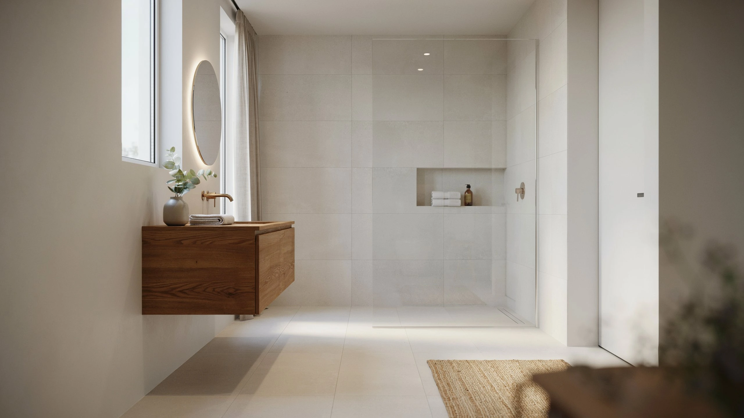 Modern Scandinavian bathroom with floating wood vanity, round backlit mirror, and frameless glass walk-in shower with tiled niche.