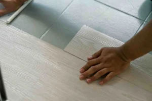 Shower Floor Tiles Non Slip installation showing textured slip resistant floor tile being placed for improved traction and safety in wet bathroom areas.