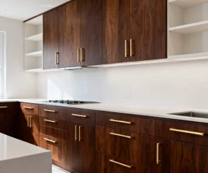 how to make oak kitchen cabinets look modern with dark wood finish, sleek gold handles, and clean white countertop design