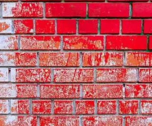 how to remove paint from brick showing partially stripped red paint revealing natural brick underneath